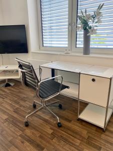ein Büro mit einem Schreibtisch und einem Stuhl in der Unterkunft Apartment Living in Schwabach