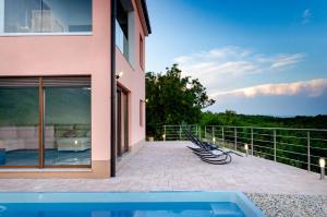 a house with a swimming pool on a balcony at Villa the View Zagore in Brseč