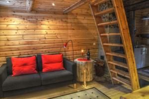 uma sala de estar com um sofá com almofadas vermelhas em Cottage On Wild River In Lapland/Sweden em Karlsten