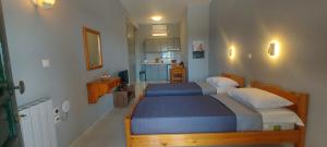 a small bedroom with two beds and a kitchen at BOSCO VERDE Corfu Apartments in Gouvia
