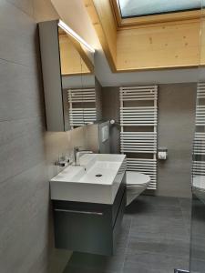 a bathroom with a white sink and a toilet at Diana 9 in Leukerbad