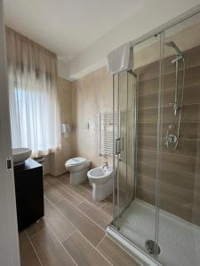 a bathroom with a toilet and a glass shower at Sport Hotel & Residence Il Bivacco del Parco in Cutura
