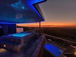 克鲁格斯多普Weston Guest House Krugersdorp的一座享有日落美景的建筑的顶部热水浴池