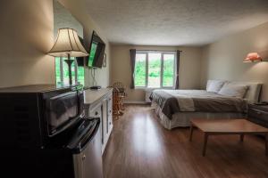 um quarto com uma cama e uma televisão de ecrã plano em Atlantic Motel em Moncton
