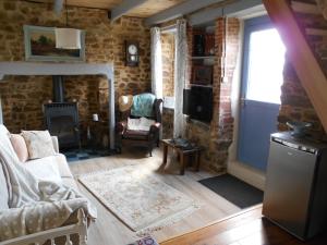 a living room with a couch and a fireplace at Les Landes Gîte in Saint-Pardoux-Corbier