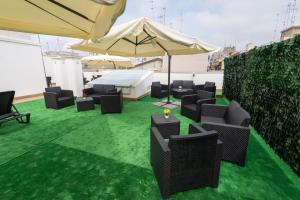a group of chairs and an umbrella on a green floor at Dream Palace in Bari