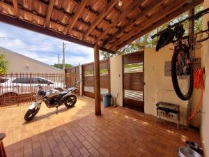 a motorcycle parked on a patio with a house at MAZZAROTTO casa completa 2 quartos in Campo Grande