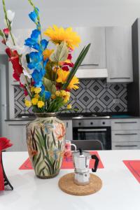 a vase filled with flowers sitting on a kitchen counter at Zagara e Lumia in Catania