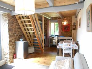 a living room with a table and a kitchen at Les Landes Gîte in Saint-Pardoux-Corbier