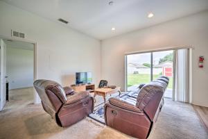 a living room with two leather chairs and a television at Bright Cypress Gardens Home Near Legoland! in Cypress Gardens