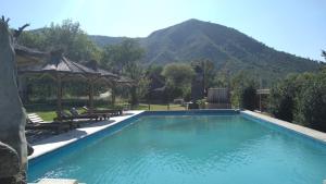 a swimming pool with a gazebo and a mountain at Hotel Bates in Villa General Belgrano