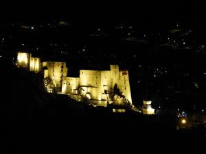 un castillo sentado en la cima de una colina por la noche en Babu Guest House, en Leh