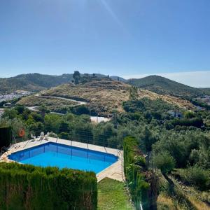 康士坦丁納的住宿－El Molino de La Quinta，享有游泳池的景色,后面是一座小山