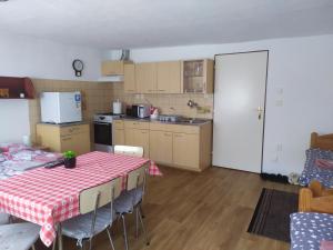捷克克魯姆洛夫的住宿－Ubytování U Jarky，厨房配有一张带红白桌布的桌子