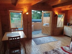 Cabaña con suelo de madera y habitación con mesa en Norwell view farm glamping with hot tubs en Bath