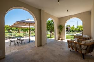 een patio met een tafel en stoelen en een parasol bij Nohasi Palace Hotel & SPA in Noha