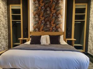 a bedroom with a large bed with a large headboard at Hôtel La Brasserie in Treignac