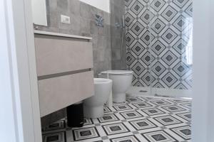 a bathroom with two toilets and a tiled floor at Zagara e Lumia in Catania