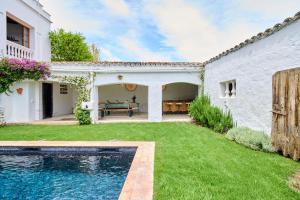 科馬魯加的住宿－Villa Masía Blanca，一个带游泳池和房子的后院