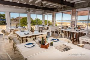 a restaurant with tables and chairs and windows at La Balsa in José Ignacio