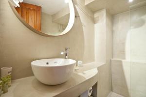 La salle de bains est pourvue d'un lavabo blanc et d'un miroir. dans l'établissement Kalyvion Apartments, à Arachova 41 autres photos