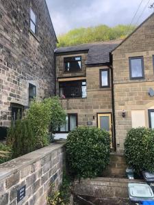 an old brick house with bushes in front of it at Hilltop House is a welcoming 2 bedroom property in Matlock