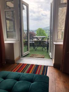 a living room with a couch and a view of a patio at Hilltop House is a welcoming 2 bedroom property in Matlock