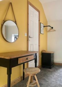 a room with a vanity with a mirror and a stool at Hilltop House is a welcoming 2 bedroom property in Matlock