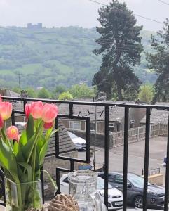 a balcony with flowers in a vase on a table at Hilltop House is a welcoming 2 bedroom property in Matlock