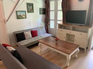 ein Wohnzimmer mit einem Sofa und einem Couchtisch in der Unterkunft Appartement L Eiffel in Coulonges