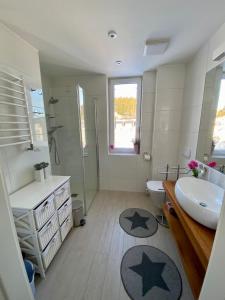 ein Badezimmer mit einem Waschbecken, einem WC und einem Spiegel in der Unterkunft Apartament Czarna Góra Livigno in Heudorf