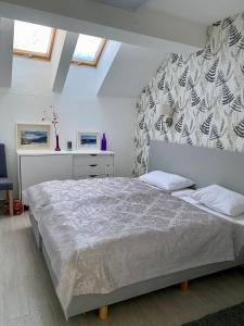 ein weißes Schlafzimmer mit einem großen Bett und Fenstern in der Unterkunft Apartament Czarna Góra Livigno in Heudorf