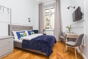 a bedroom with a bed and a desk and a television at Traveler's Best Choice - Old Town Guesthouse in Kraków