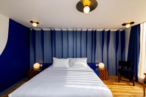 una camera da letto con un grande letto con pareti blu di Limehouse Library Hotel a Londra