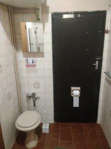 a bathroom with a toilet and a black door at The Pool House @ Salbu in Centurion
