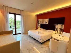 a bedroom with a large bed and a table and chairs at Hotel Alpha in Sant'Agnello