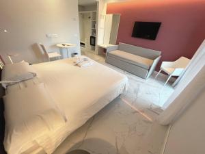 a bedroom with a large white bed and a couch at Hotel Alpha in Sant'Agnello