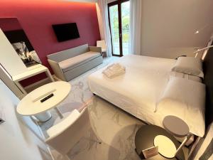 a bedroom with a white bed and a red wall at Hotel Alpha in Sant'Agnello
