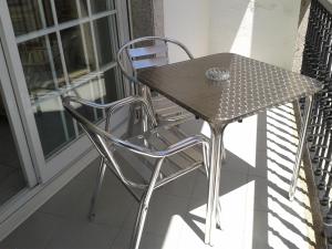einen Tisch und zwei Stühle auf dem Balkon in der Unterkunft Hotel Cervantes in Sanxenxo