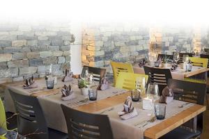 a dining room with tables and chairs and a brick wall at Hotel Roggen in Erschmatt