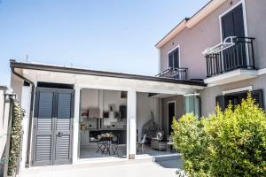 a house with sliding doors and a patio at B&B Màkari holiday home in Barcellona-Pozzo di Gotto