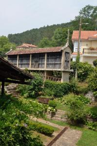 an old house with a garden in front of it at Casa Dos Cregos in Bascuas