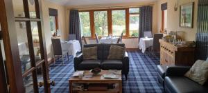 a living room with couches and a table at Riverside House in Callander