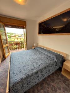 a bedroom with a bed with a blue comforter at DOLOMITI HOUSE 9 in Fiera di Primiero