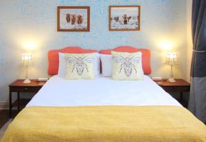 - une chambre avec un grand lit blanc et deux lampes dans l'établissement The BeeKeeper's Inn, à Louis Trichardt
