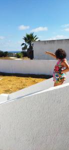 a young girl is standing on a wall at l' Escapade 