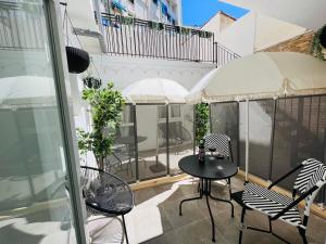 COOL LOFTS ALAMEDA VALENCIA في فالنسيا: فناء مع طاولة وكراسي على شرفة