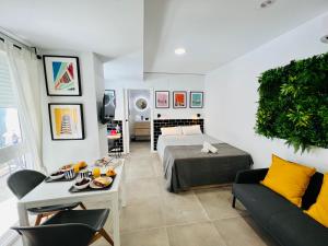 COOL LOFTS ALAMEDA VALENCIA في فالنسيا: غرفة معيشة بها سرير وأريكة