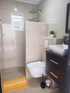 Un baño blanco con inodoro y lavabo. en CG Apartment - Kibrahacha, en Willemstad