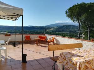 un patio con mesa, sillas y sombrilla en Agriturismo Le Terre d'Abruzzo Country House en Alanno